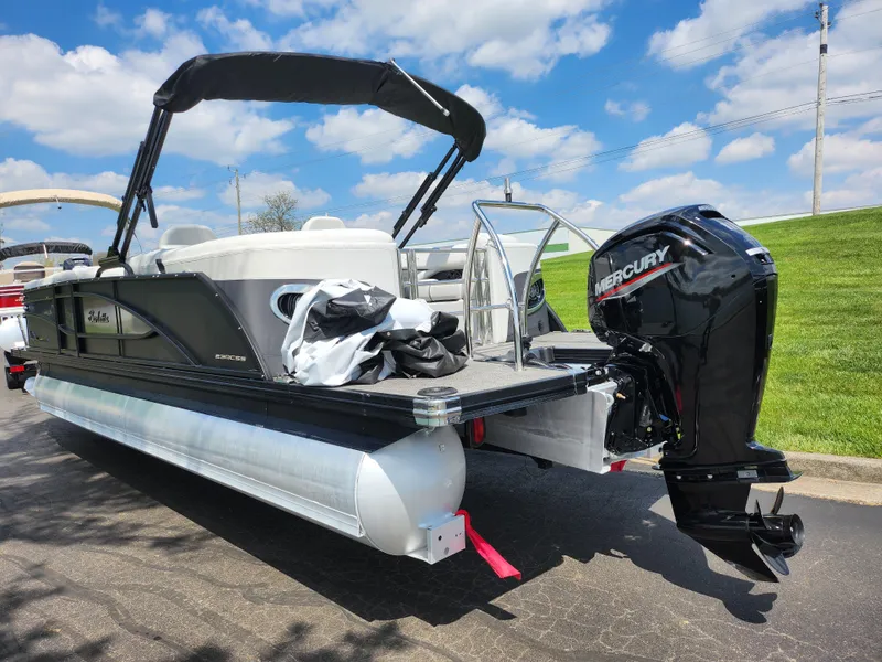 Slide: The Image of 2021 Barletta CORSA 23QC pontoon boat with Mercury outboard motor, parked on pavement. - 3