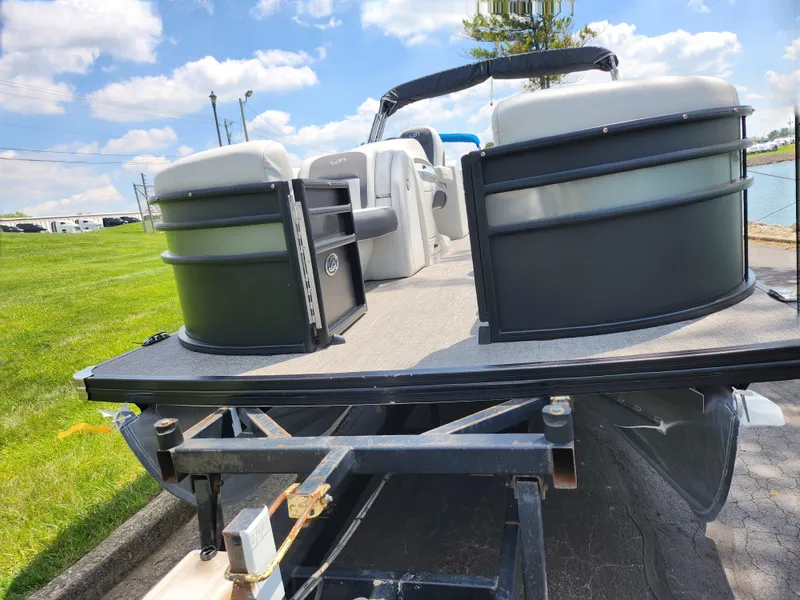 Slide: The Image of 2021 Barletta CORSA 23QC pontoon boat on trailer, parked outdoors under blue sky. - 6