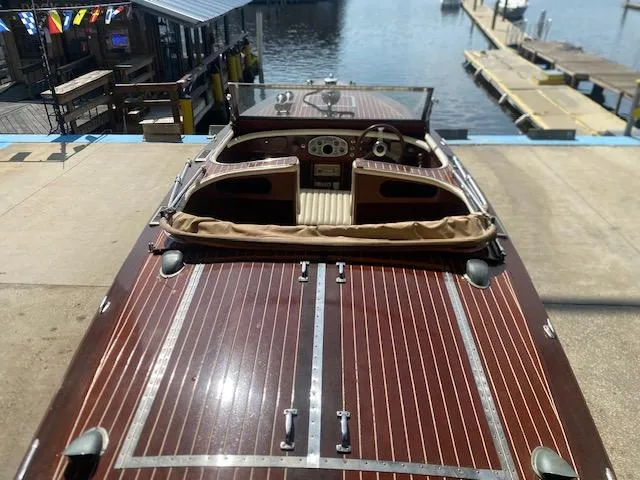 Slide: The Image of 2000 Grand Craft Classic Runabout boat with wooden deck at a marina. - 10