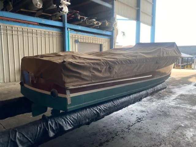 Slide: The Image of Covered 2000 Grand Craft Classic Runabout boat in storage facility. - 15