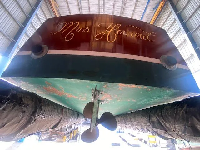 Slide: The Image of Grand Craft Classic Runabout 2000, named "Mrs. Howard," in a boatyard, viewed from below. - 18