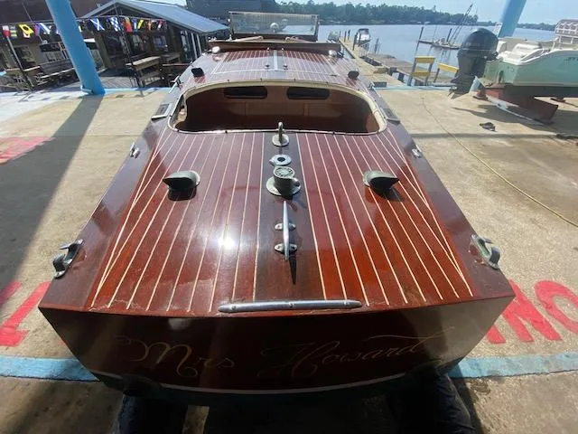 Slide: The Image of Grand Craft Classic Runabout 2000, wooden boat docked by the waterfront. - 7