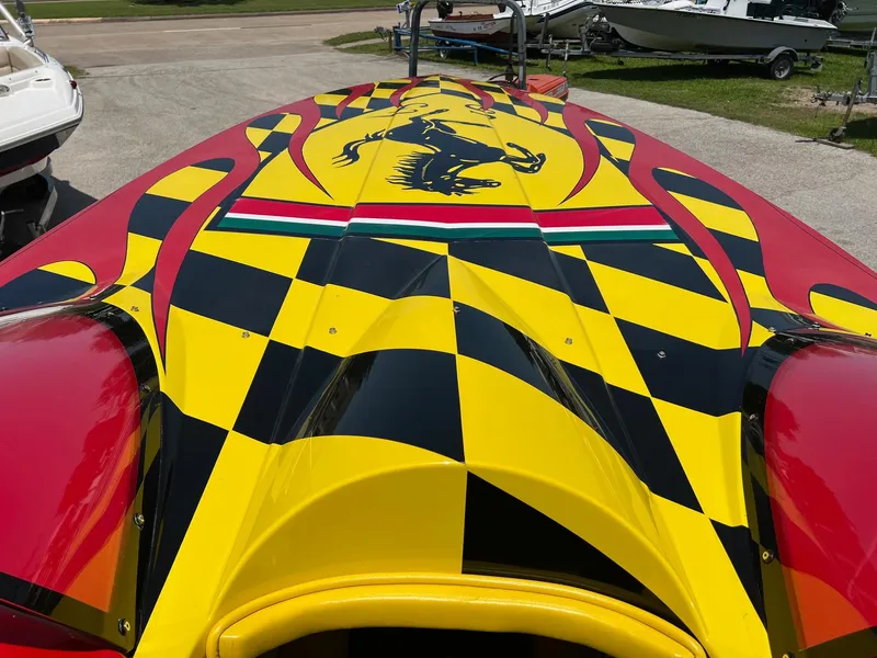 Slide: The Image of Colorful 2006 Kachina Drone 26 boat with vibrant checkered design and prancing horse graphic. - 17