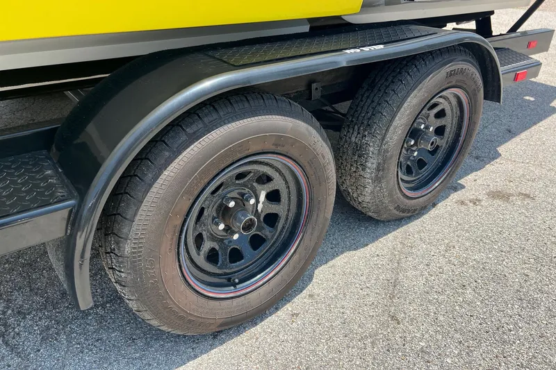 Slide: The Image of Trailer wheels of a 2006 Kachina Drone 26 on asphalt surface. - 29