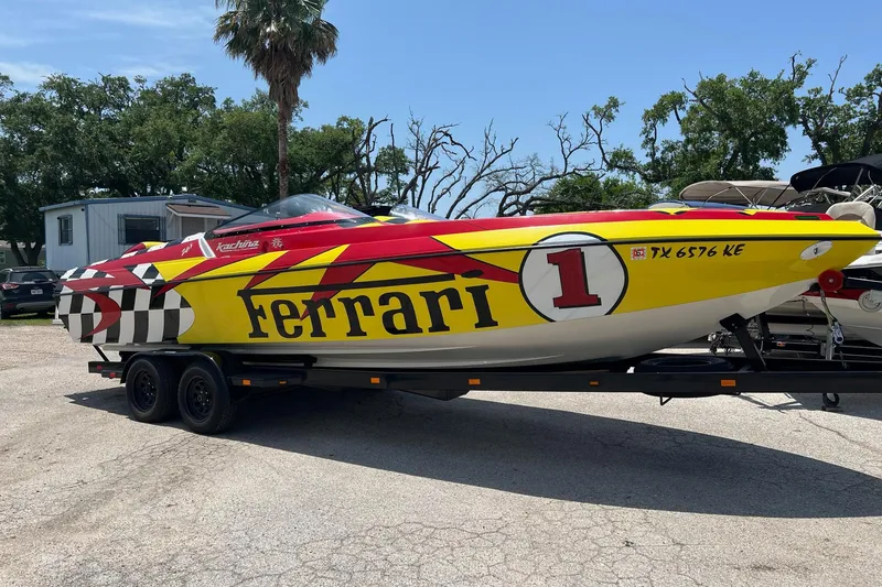 Slide: The Image of Colorful Kachina Drone 26 speedboat with Ferrari-themed design on a trailer. - 30
