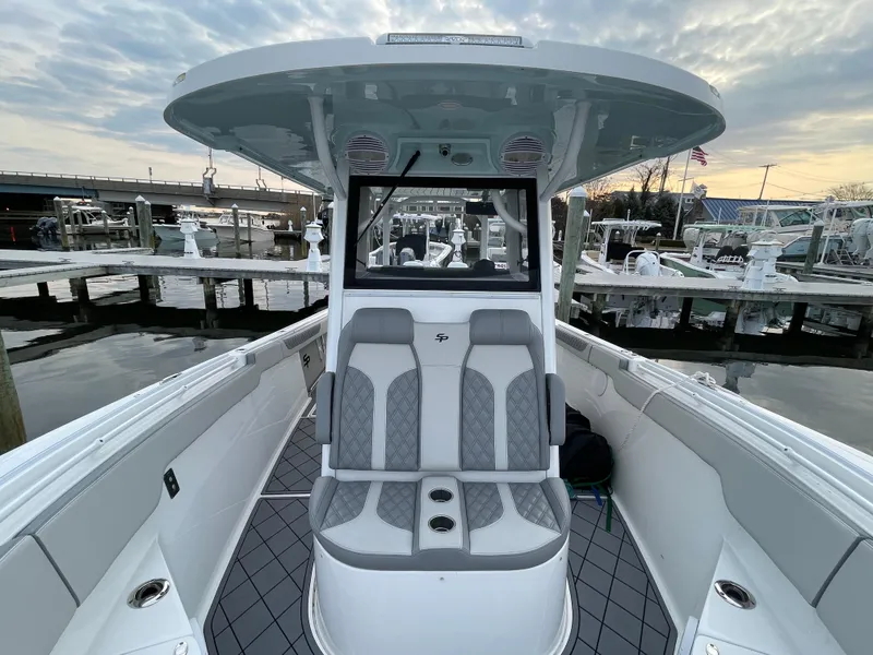 Slide: The Image of 2023 Sea Pro 320 DLX Offshore boat interior with seating, docked at marina. - 12