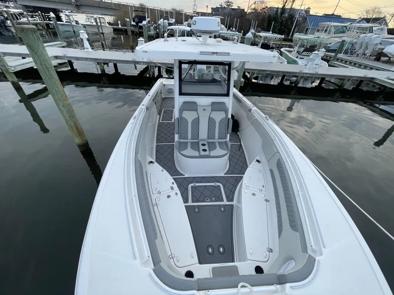 Slide: The Image of 2023 Sea Pro 320 DLX Offshore boat docked at marina, showcasing spacious deck and seating. - 14