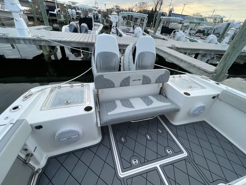 Slide: The Image of 2023 Sea Pro 320 DLX Offshore boat interior with seating and storage at marina. - 15