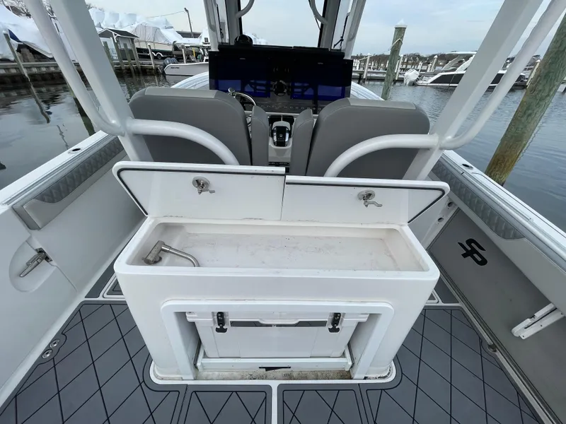 Slide: The Image of 2023 Sea Pro 320 DLX Offshore boat interior with helm and storage area. - 18