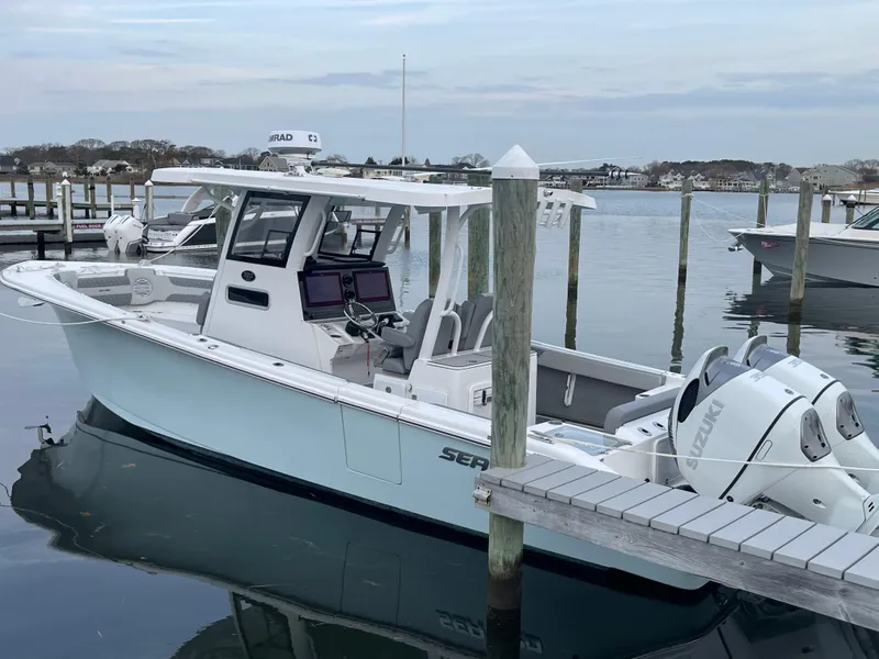 Slide: The Image of 2023 Sea Pro 320 DLX Offshore boat docked at a marina. - 2