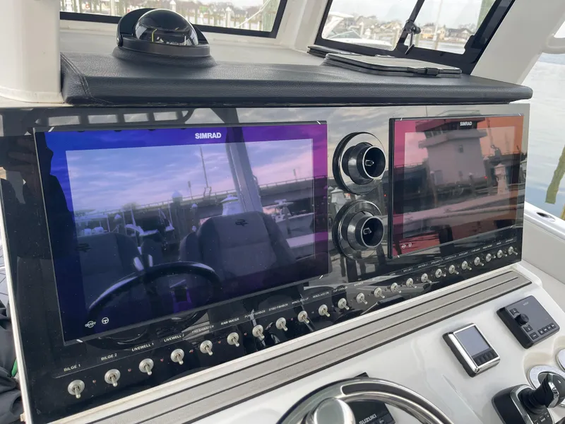 Slide: The Image of 2023 Sea Pro 320 DLX Offshore dashboard with dual Simrad displays and controls. - 5