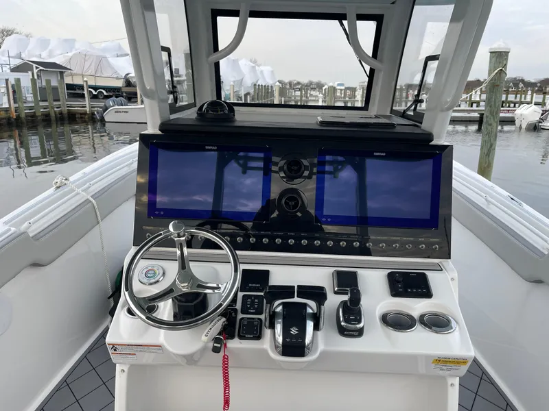 Slide: The Image of 2023 Sea Pro 320 DLX Offshore helm with dual screens and modern controls. - 6