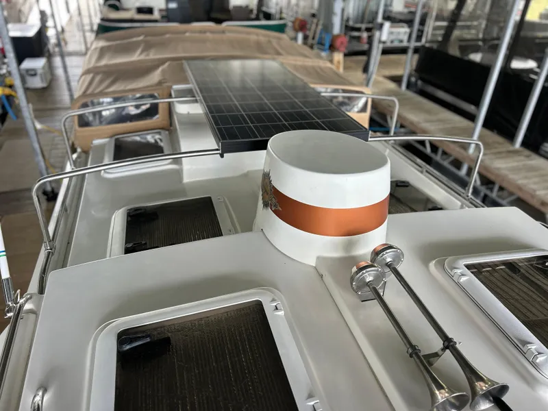 Slide: The Image of 2016 Ranger Tugs R-25SC boat with solar panel and deck details in a marina setting. - 17