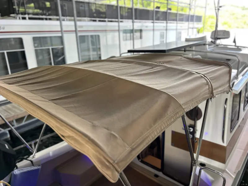 Slide: The Image of 2016 Ranger Tugs R-25SC boat with beige canopy in marina setting. - 19