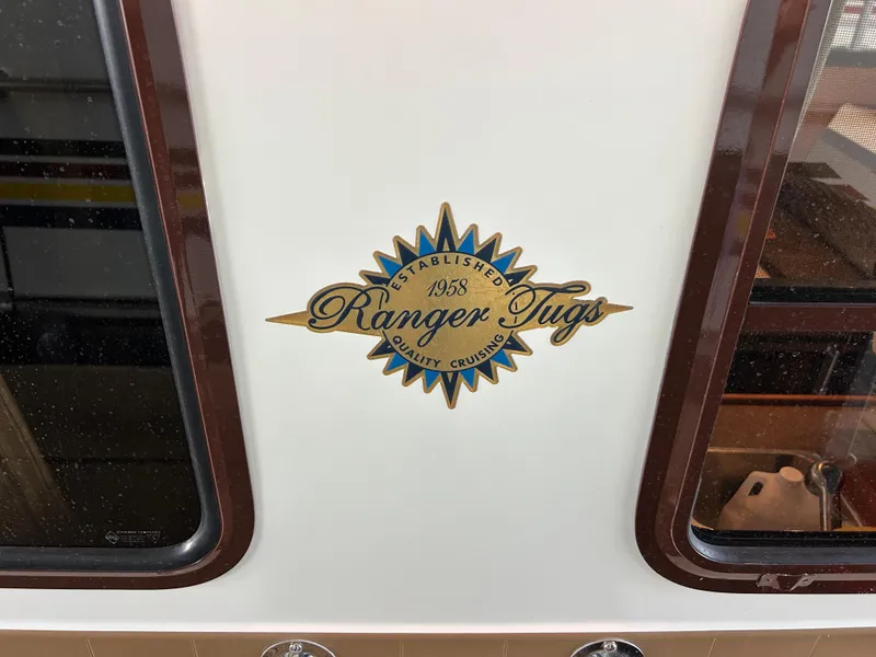 Slide: The Image of 2016 Ranger Tugs R-25SC emblem on boat exterior, showcasing brand logo and design. - 20