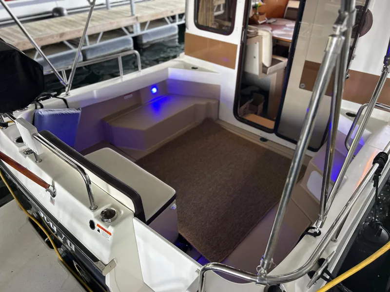 Slide: The Image of 2016 Ranger Tugs R-25SC boat interior with seating and blue accent lighting. - 22