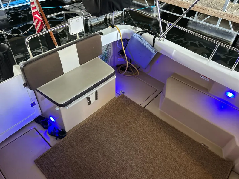 Slide: The Image of 2016 Ranger Tugs R-25SC boat interior with seating, blue lighting, and American flag. - 23