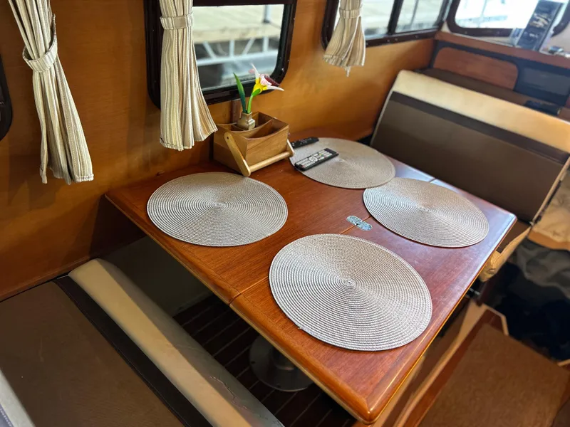 Slide: The Image of 2016 Ranger Tugs R-25SC interior dining area with table and placemats. - 26