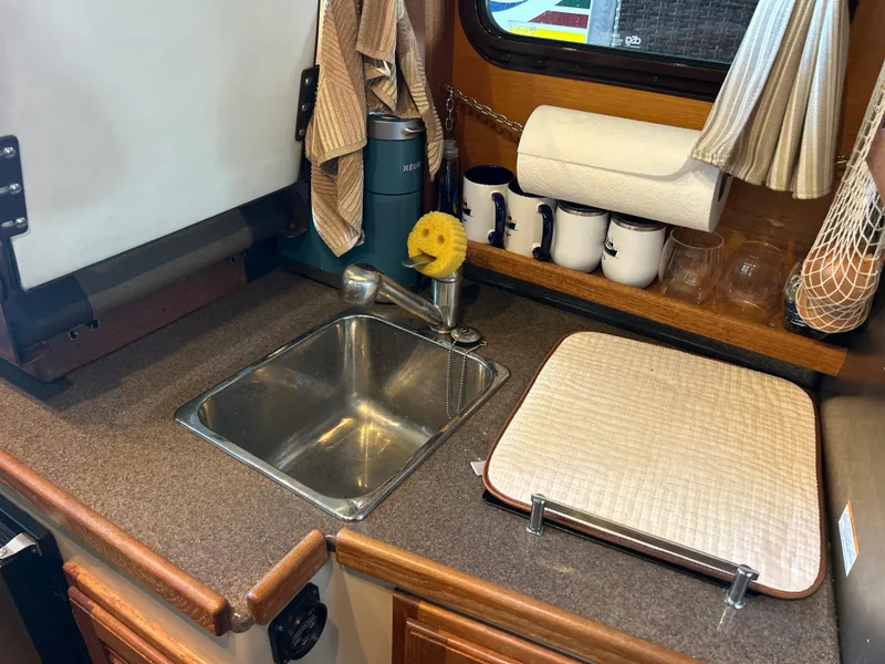 Slide: The Image of 2016 Ranger Tugs R-25SC boat kitchen with sink, countertop, and storage. - 27