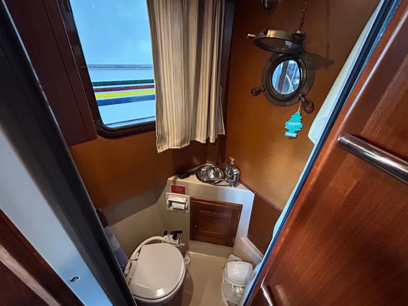 Slide: The Image of 2016 Ranger Tugs R-25SC boat bathroom with porthole, sink, and toilet. - 34