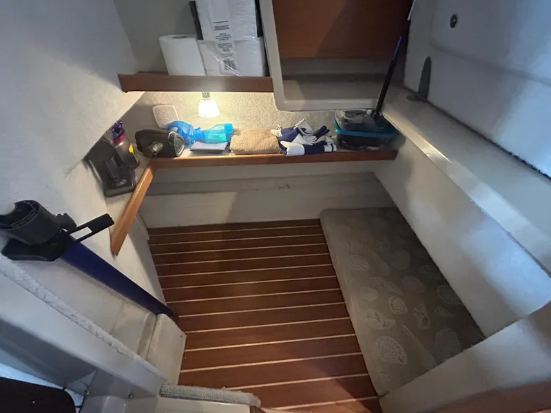 Slide: The Image of 2016 Ranger Tugs R-25SC cabin interior with wooden flooring and storage shelves. - 38