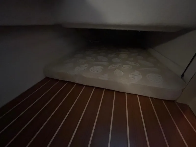 Slide: The Image of 2016 Ranger Tugs R-25SC cabin interior with patterned mattress and wooden flooring. - 39