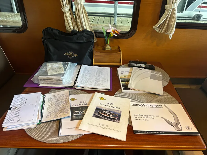 Slide: The Image of Manuals and documents on a Ranger Tugs R-25SC boat table, 2016 model. - 41