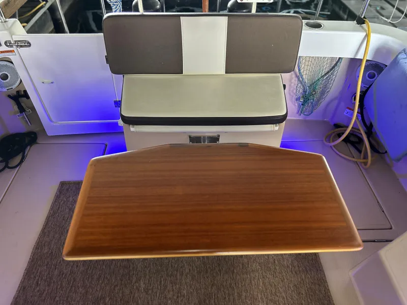 Slide: The Image of 2016 Ranger Tugs R-25SC interior with wooden table and cushioned seating. - 42