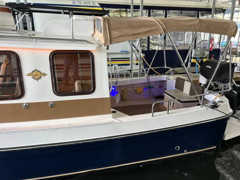 Slide: The Image of 2016 Ranger Tugs R-25SC boat with canopy, docked in a marina. - 5