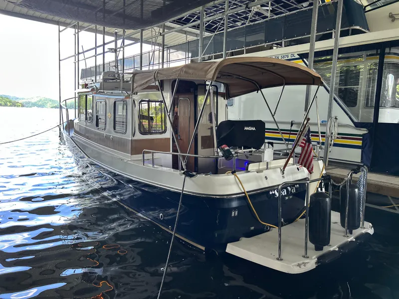 Slide: The Image of 2016 Ranger Tugs R-25SC boat docked in a marina, featuring a covered deck. - 7