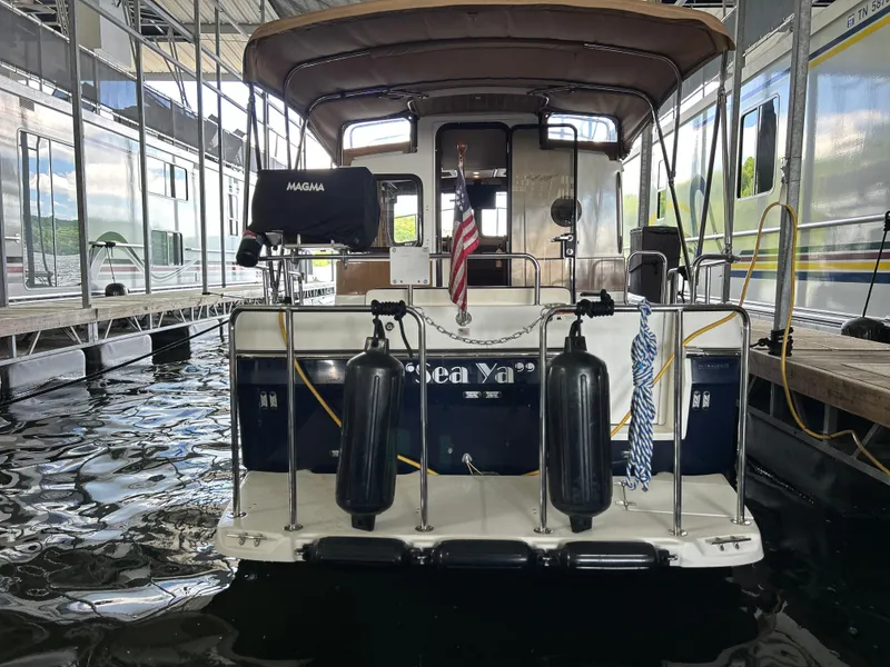 Slide: The Image of 2016 Ranger Tugs R-25SC docked, rear view with American flag and fenders. - 9