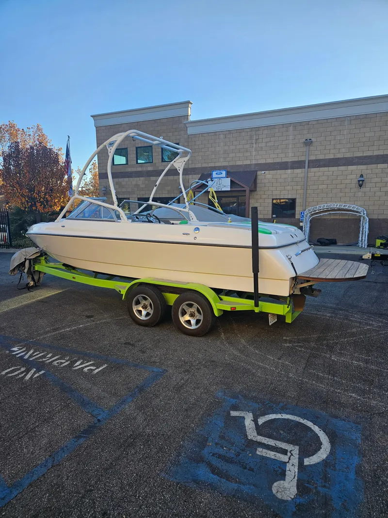 Slide: The Image of 2005 Tigé 22V boat on a trailer in a parking lot. - 1