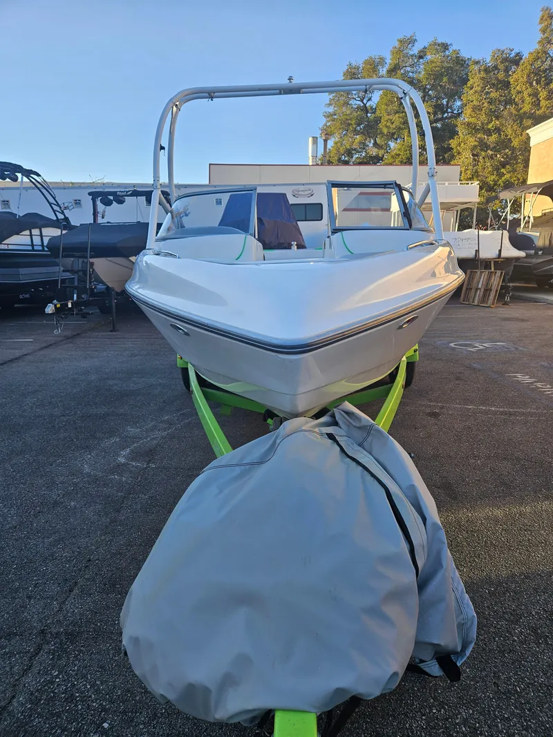 Slide: The Image of 2005 Tigé 22V boat on trailer, parked outdoors, with a cover on the front. - 10