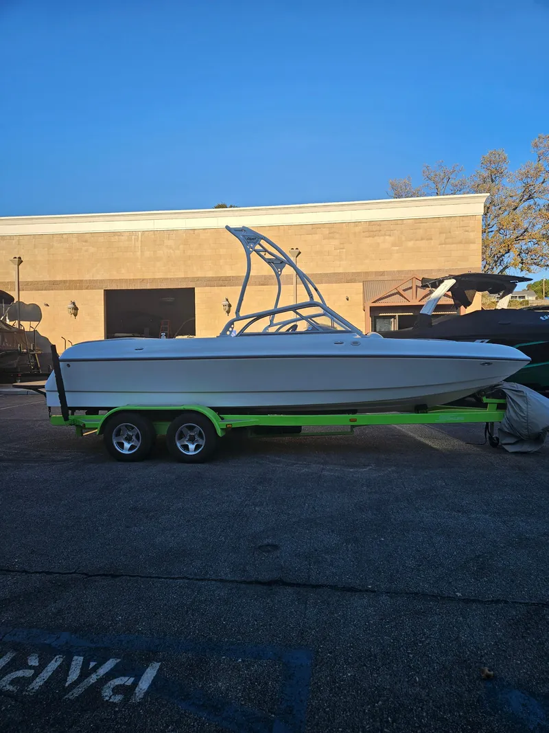 Slide: The Image of 2005 Tigé 22V boat on a trailer, parked outside a building under a clear blue sky. - 11