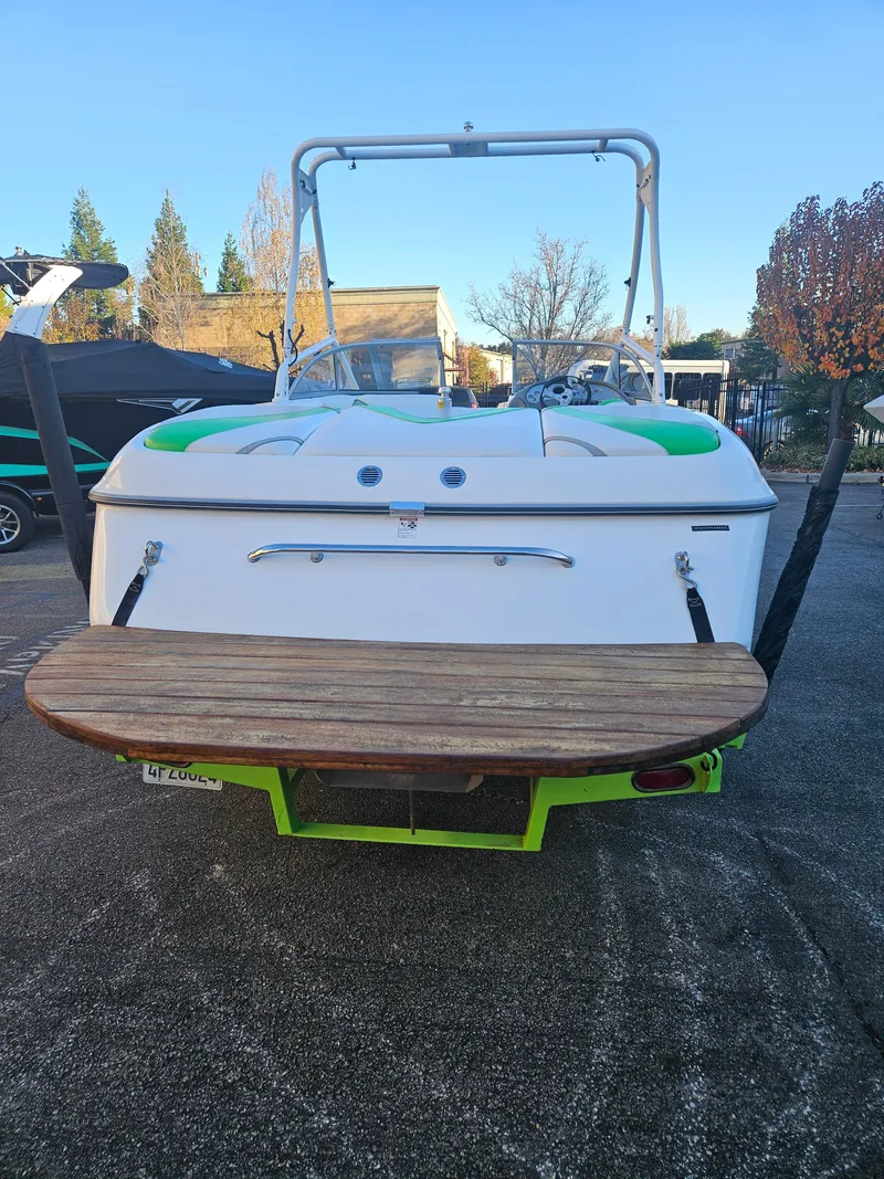 Slide: The Image of 2005 Tigé 22V boat rear view with swim platform in a parking area. - 12