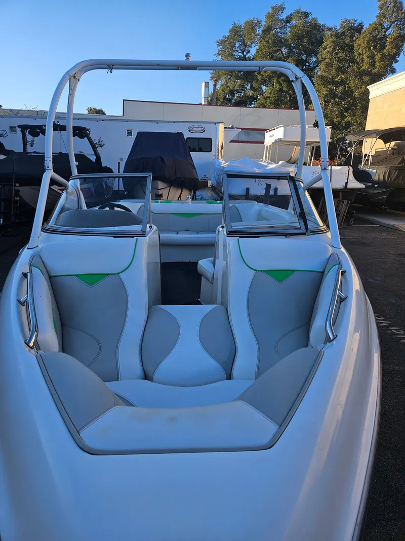 Slide: The Image of 2005 Tigé 22V boat with white and green interior, parked outdoors. - 4