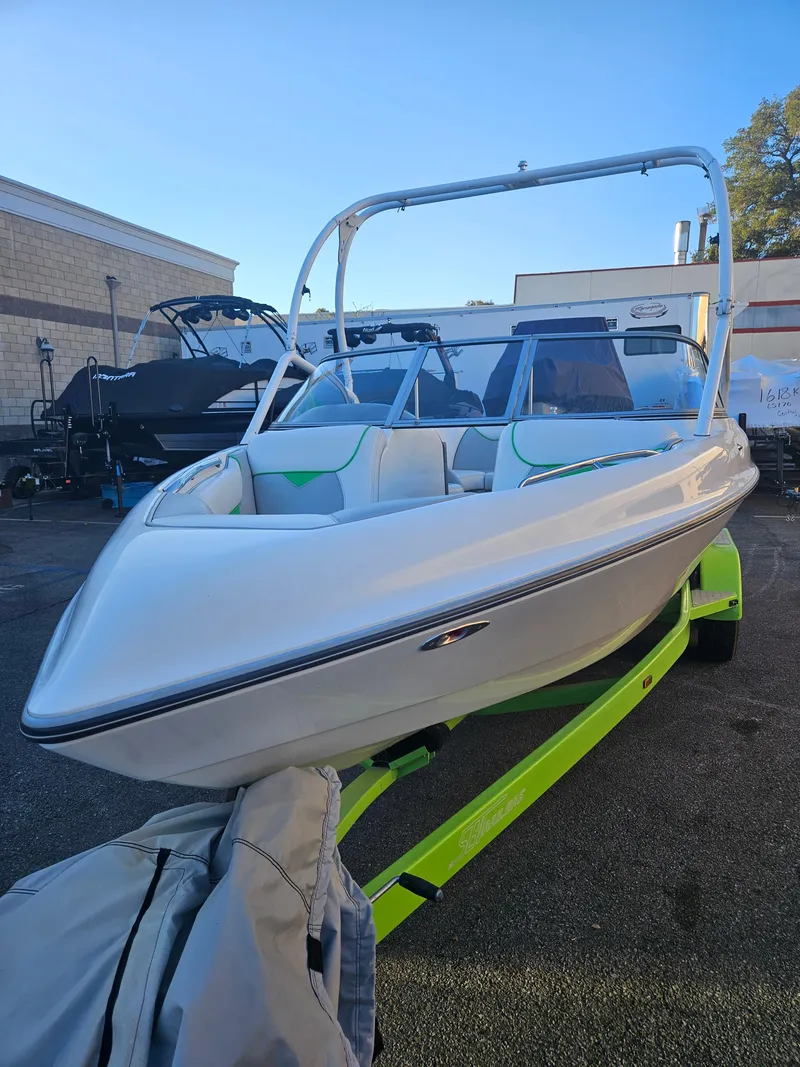 Slide: The Image of 2005 Tigé 22V boat on a neon green trailer, parked outdoors. - 9