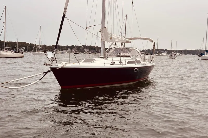 Slide: The Image of 2003 Catalina 36 MkII sailboat anchored in a calm harbor with other boats. - 1