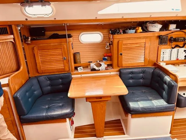 Slide: The Image of 2003 Catalina 36 MkII interior with wooden cabinetry and blue cushioned seating. - 21
