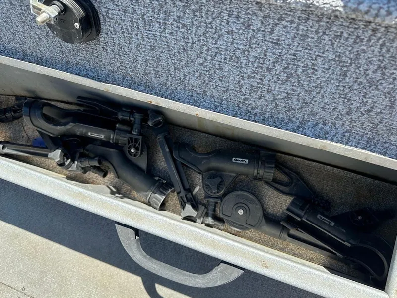 Slide: The Image of Storage compartment in 2018 Alumacraft Yukon 165 boat with fishing rod holders. - 21