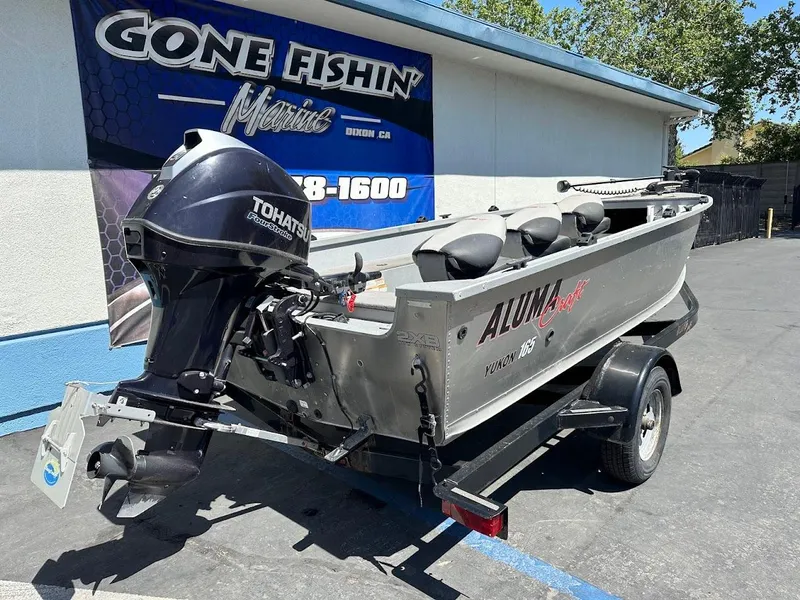 Slide: The Image of 2018 Alumacraft Yukon 165 boat with Tohatsu motor on trailer, parked outside dealership. - 7