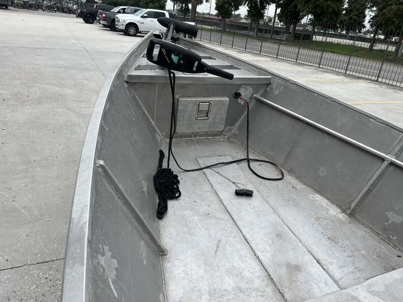 Slide: The Image of Aluminum boat interior with motor and rope, parked in a lot. - 11