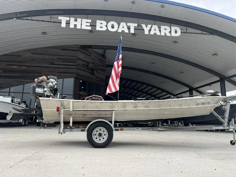 Slide: The Image of Custom 2006 model 17 boat on trailer at The Boat Yard, displaying American flag. - 2