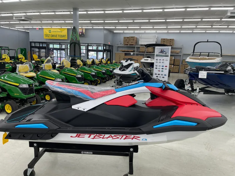 Slide: The Image of 2025 Yamaha WaveRunner JetBlaster DLX 3-Up in showroom, vibrant red and blue design. - 4