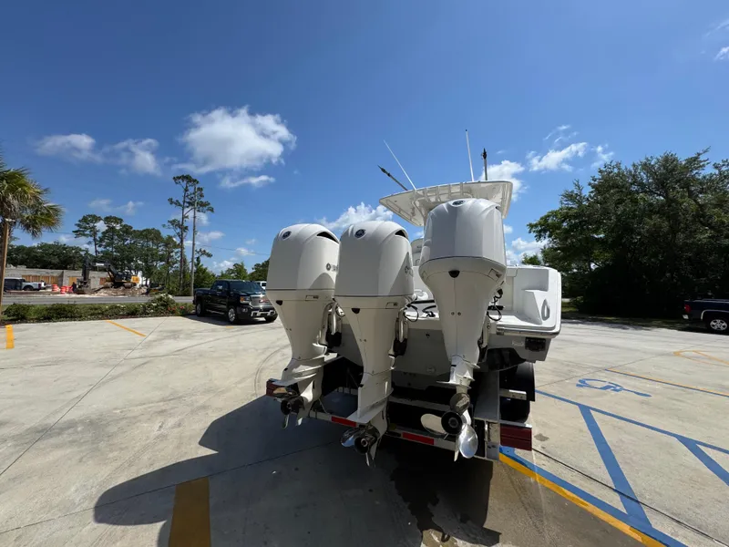 Slide: The Image of 2018 Jupiter 34 HFS boat with triple outboard engines in a parking lot. - 14
