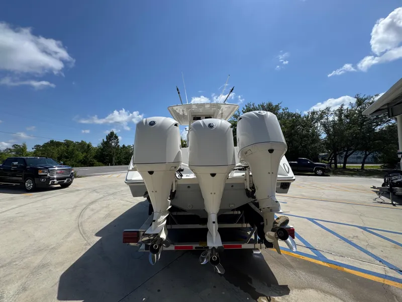 Slide: The Image of 2018 Jupiter 34 HFS boat with triple outboard engines in a sunny parking lot. - 15