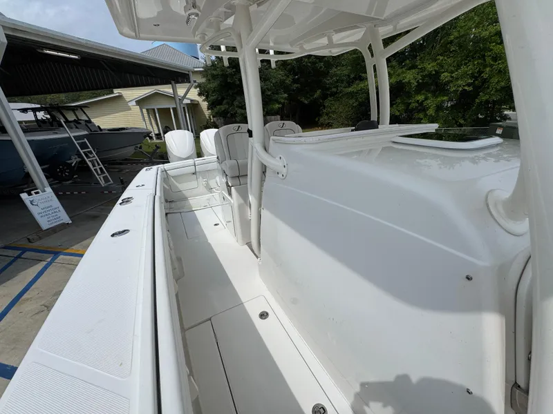 Slide: The Image of 2018 Jupiter 34 HFS boat interior with seating and console, docked outdoors. - 26