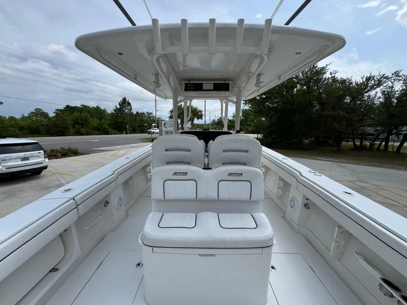 Slide: The Image of 2018 Jupiter 34 HFS boat interior with seating and console, docked outdoors. - 33