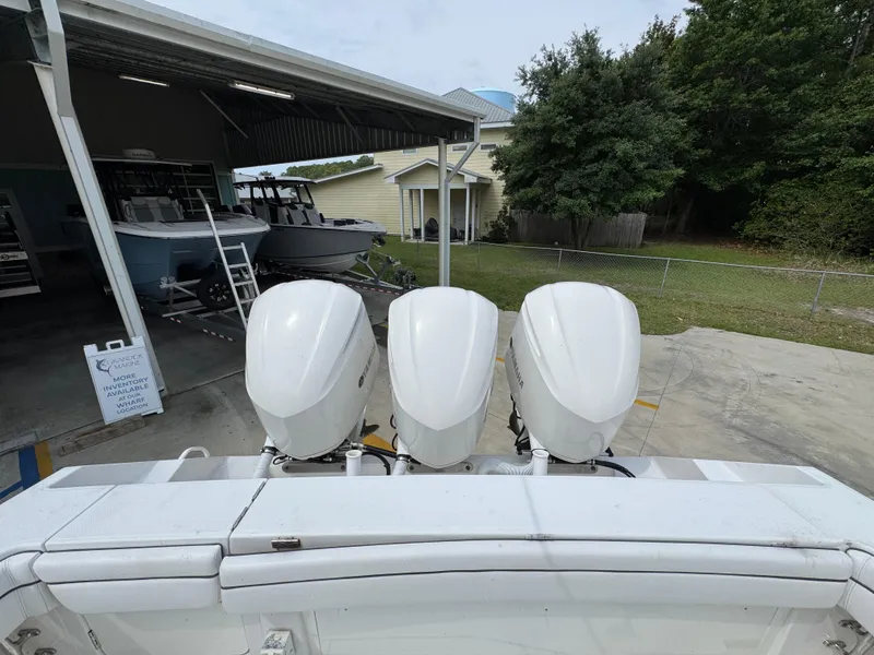 Slide: The Image of 2018 Jupiter 34 HFS boat with triple outboard engines in a marina setting. - 36