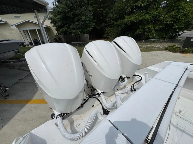 Slide: The Image of Triple outboard engines on a 2018 Jupiter 34 HFS boat, parked outdoors. - 38